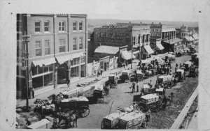 black and white photo of a street in Chandler with horse-drawn wagons 