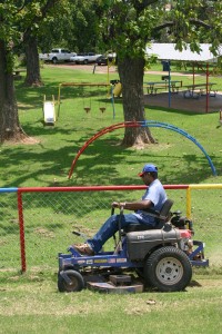 Man driving a ride-on lawn mower in the park